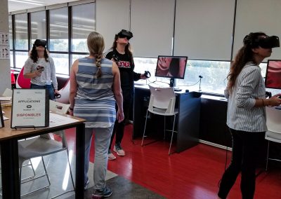 La professeur guide trois étudiantes qui observent l'intérieur du coeur à l'aide de la réalité virtuelle à partir d'un poste Oculus Rift avec l'application ShareCare.